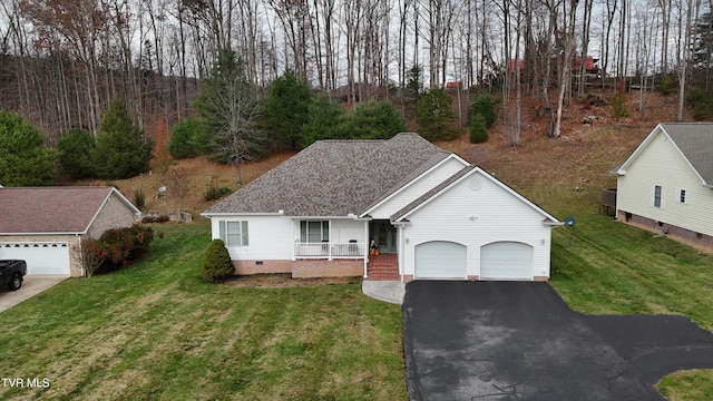 view of front of home featuring covered porch, a garage, and a front lawn