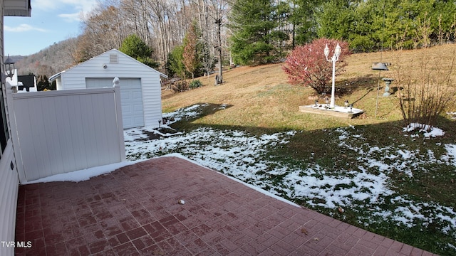 yard covered in snow with a garage and an outdoor structure