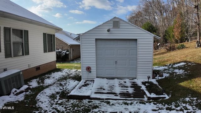 snow covered garage with central AC