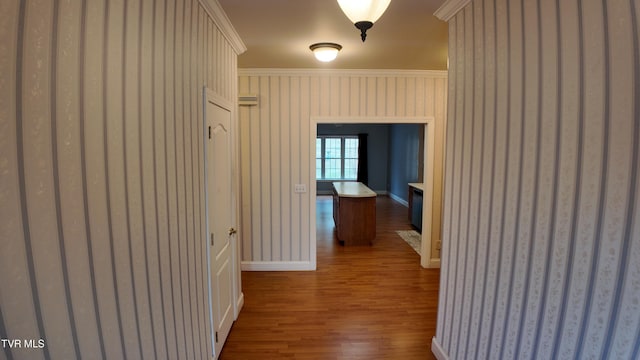 hallway with hardwood / wood-style flooring and crown molding