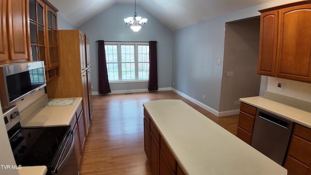 kitchen with appliances with stainless steel finishes, light hardwood / wood-style flooring, backsplash, lofted ceiling, and pendant lighting