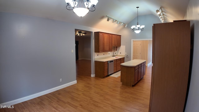 kitchen with hanging light fixtures, lofted ceiling, stainless steel dishwasher, a center island, and sink