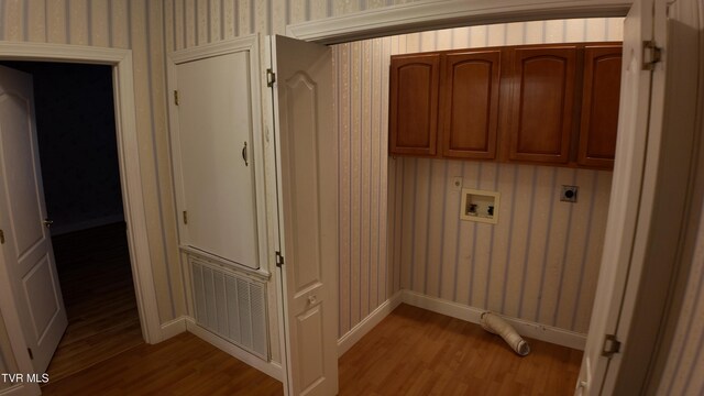 washroom with cabinets, hookup for an electric dryer, hookup for a washing machine, and light hardwood / wood-style floors