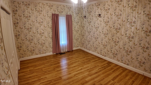 spare room with hardwood / wood-style floors and ornamental molding