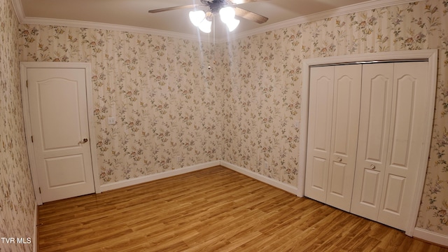 unfurnished bedroom featuring ceiling fan, a closet, crown molding, and light hardwood / wood-style floors