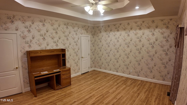 unfurnished bedroom featuring ceiling fan, light hardwood / wood-style floors, and a raised ceiling