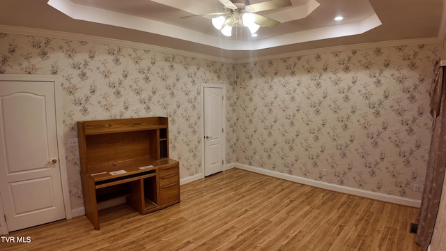 unfurnished office featuring a tray ceiling, ceiling fan, and hardwood / wood-style flooring