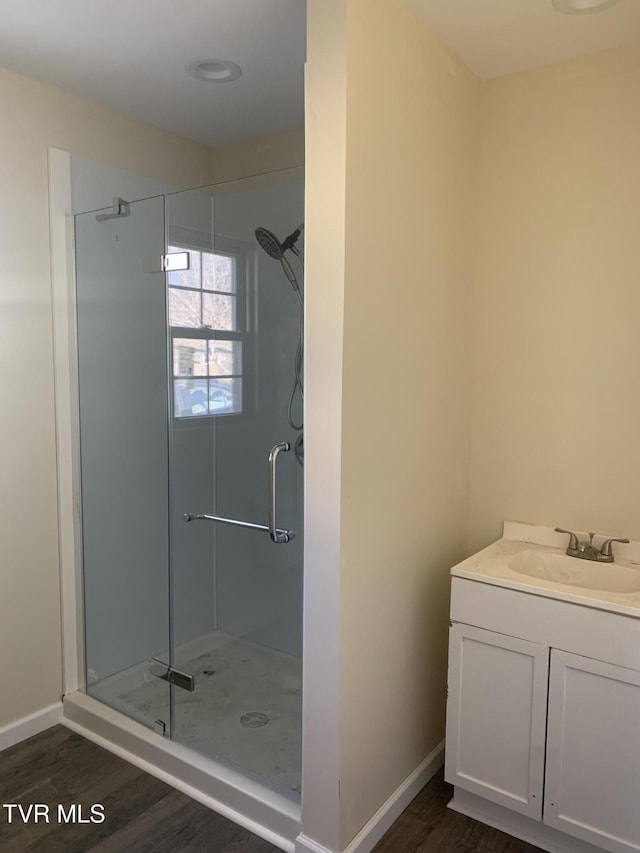 bathroom with vanity, wood-type flooring, and an enclosed shower