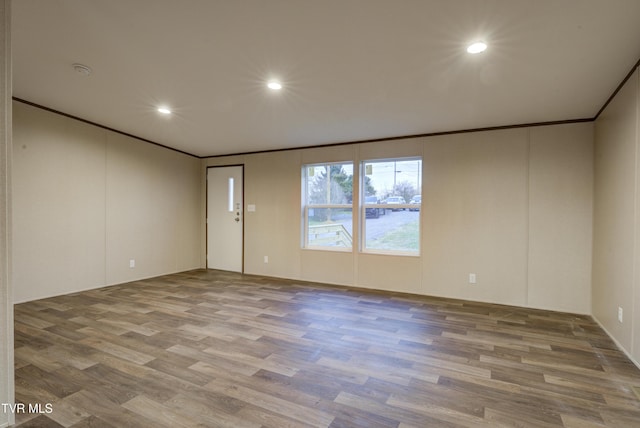 spare room featuring hardwood / wood-style floors and crown molding