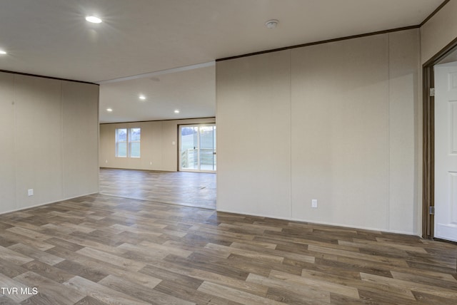 spare room featuring hardwood / wood-style flooring and ornamental molding