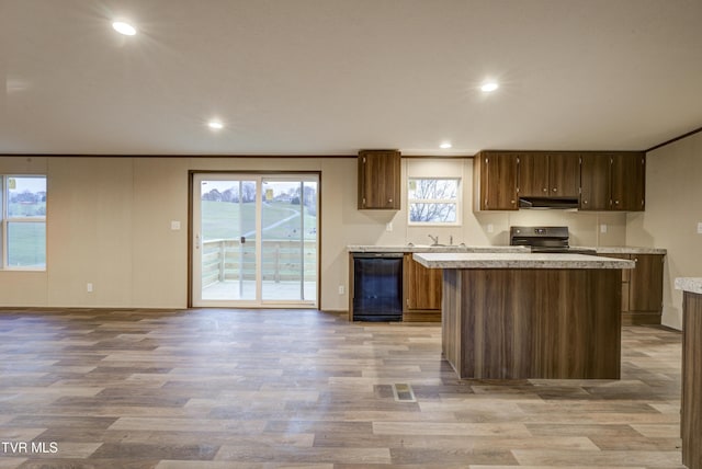 kitchen featuring light wood-type flooring, a center island, plenty of natural light, and black appliances