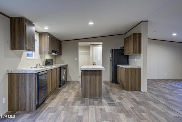 kitchen with lofted ceiling, black appliances, ventilation hood, light hardwood / wood-style flooring, and ornamental molding