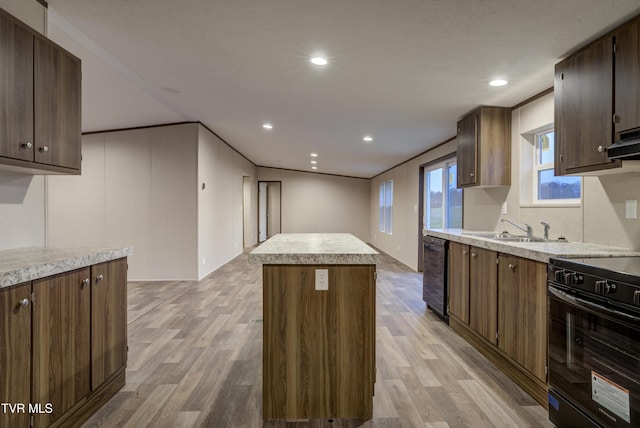 kitchen with black range oven, sink, a kitchen island, and light wood-type flooring