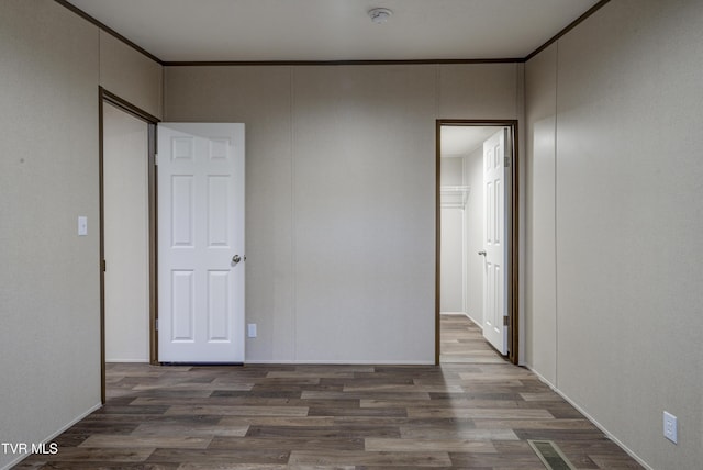 unfurnished bedroom with dark hardwood / wood-style flooring and ornamental molding