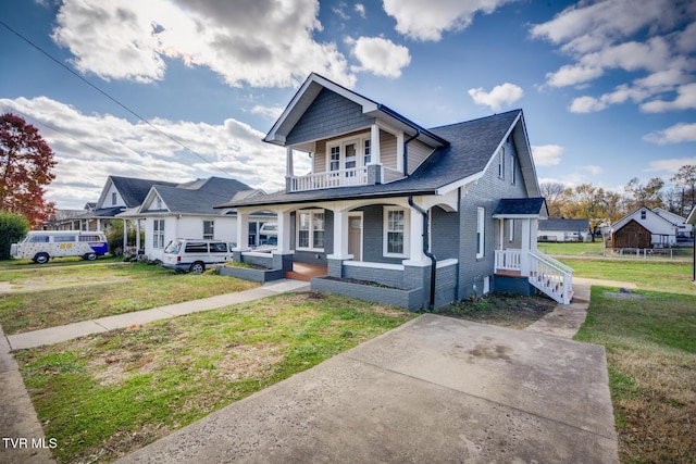 bungalow-style house featuring covered porch and a front lawn