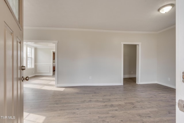 spare room with light wood-type flooring and crown molding