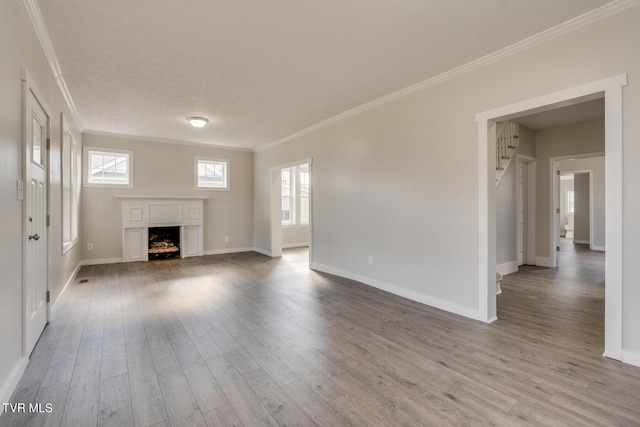 unfurnished living room featuring ornamental molding and hardwood / wood-style flooring