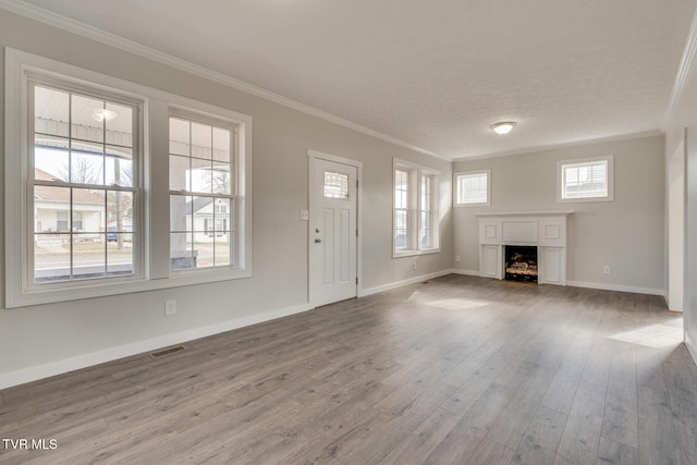 unfurnished living room featuring wood-type flooring and ornamental molding