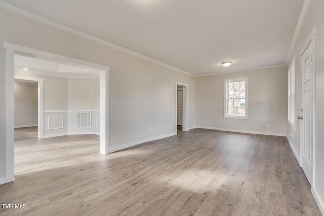 spare room with light wood-type flooring and ornamental molding