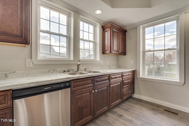 kitchen featuring dishwasher, a healthy amount of sunlight, sink, and light hardwood / wood-style flooring