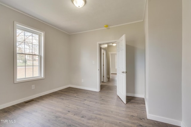 unfurnished room with light hardwood / wood-style flooring and ornamental molding