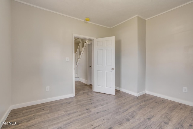 unfurnished room featuring light hardwood / wood-style floors and crown molding