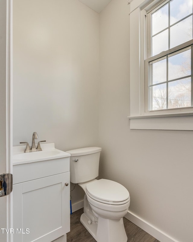 bathroom with wood-type flooring, vanity, and toilet