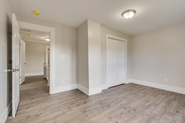 unfurnished bedroom featuring light hardwood / wood-style floors and a closet