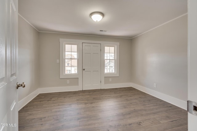 foyer entrance featuring crown molding and dark hardwood / wood-style floors