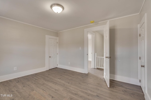 spare room featuring crown molding and wood-type flooring