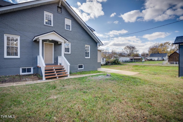 back of property featuring a lawn