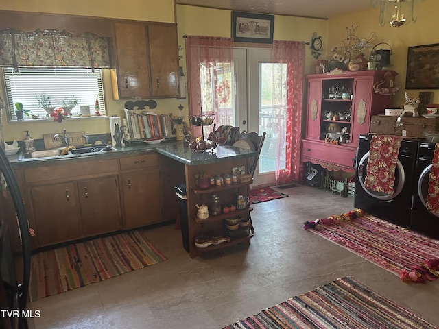 kitchen featuring french doors, concrete floors, separate washer and dryer, and sink