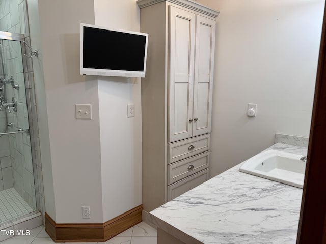 bathroom featuring tile patterned floors, vanity, and a shower with shower door