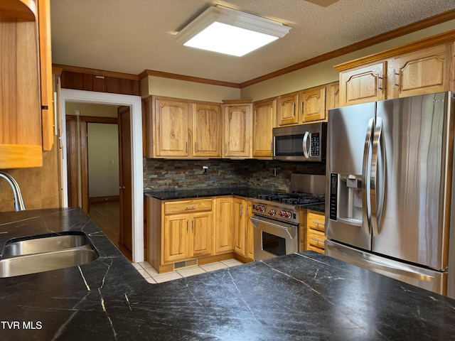 kitchen with sink, crown molding, a textured ceiling, decorative backsplash, and appliances with stainless steel finishes