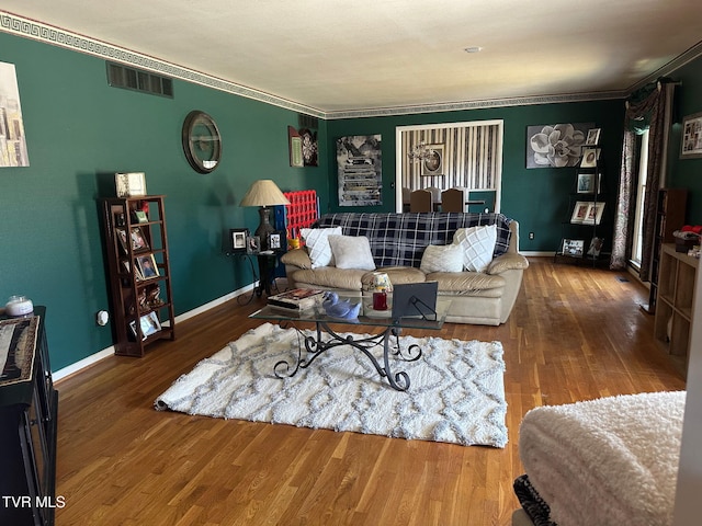 living room with wood-type flooring and ornamental molding