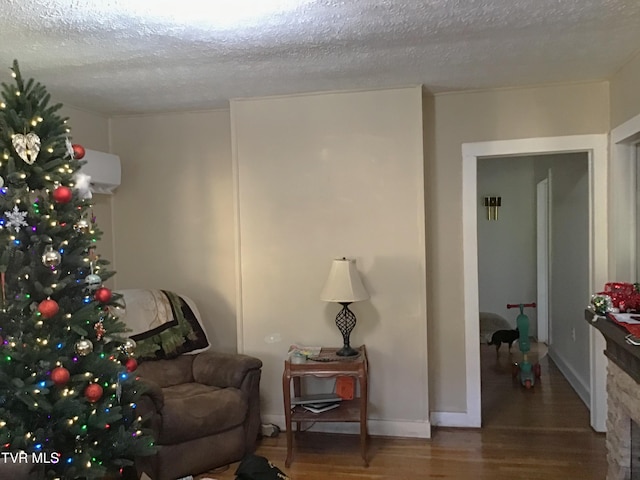 living area with hardwood / wood-style floors and a textured ceiling