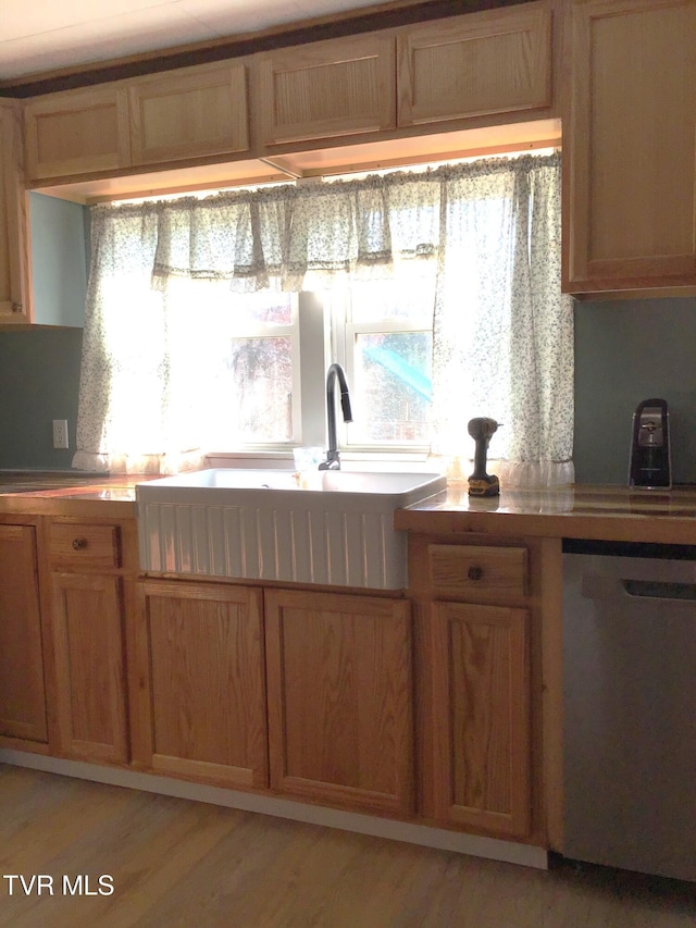 kitchen featuring stainless steel dishwasher, plenty of natural light, sink, and light hardwood / wood-style flooring