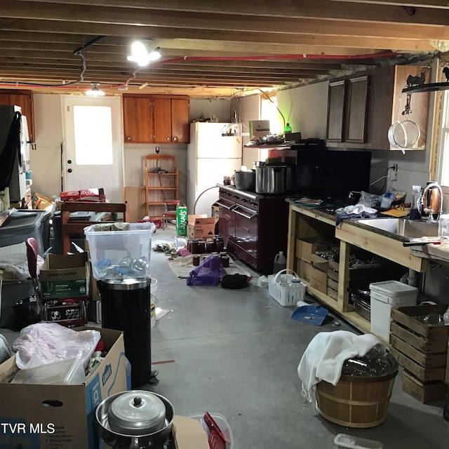 basement with a workshop area and white fridge