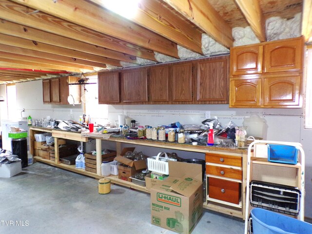 kitchen with light countertops, concrete flooring, and brown cabinets