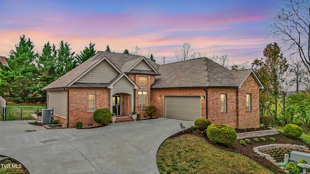 view of front of house with a garage and central AC