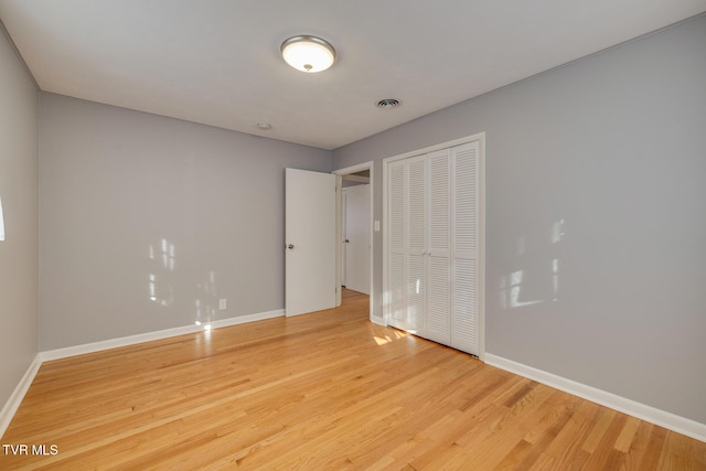 unfurnished bedroom with a closet and hardwood / wood-style floors