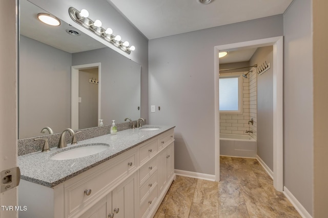 bathroom with tiled shower / bath combo and vanity