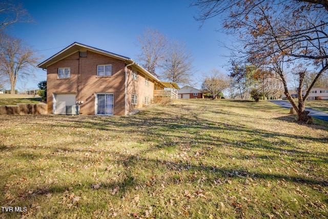 rear view of house with a yard and a garage