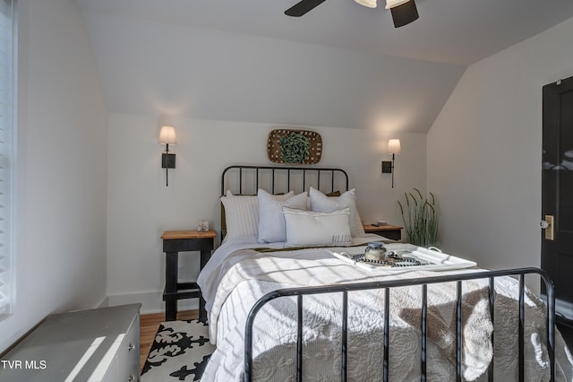 bedroom featuring ceiling fan, wood-type flooring, and lofted ceiling