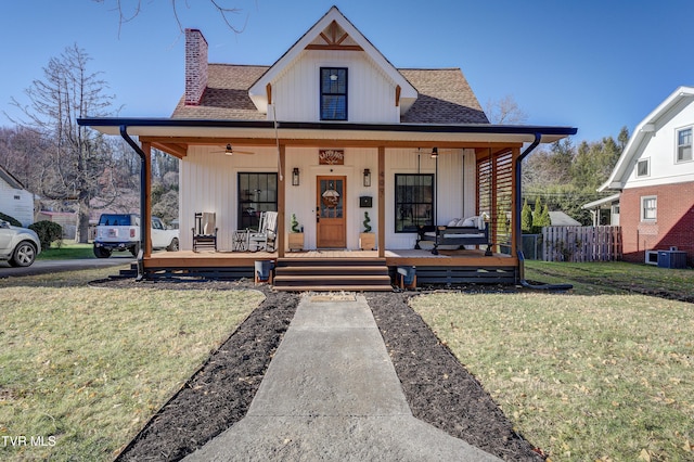 modern farmhouse with central air condition unit, ceiling fan, covered porch, and a front yard