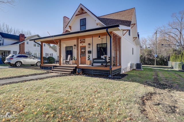 view of front of property with central AC, a porch, and a front yard