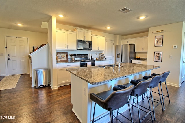 kitchen with black appliances, dark hardwood / wood-style floors, a center island with sink, and sink