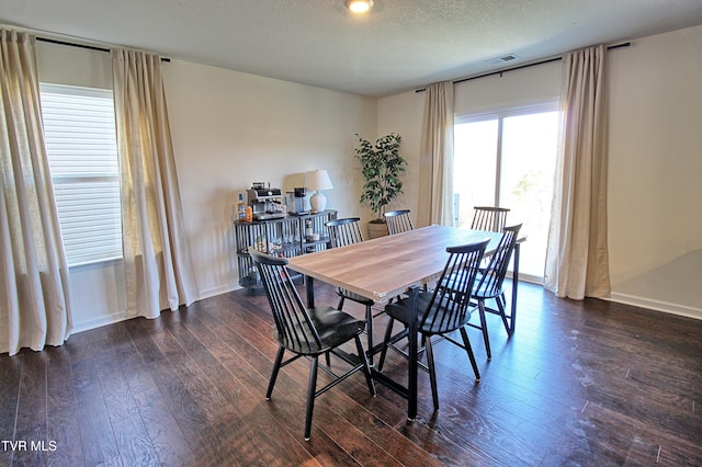 dining room featuring dark hardwood / wood-style flooring and a textured ceiling