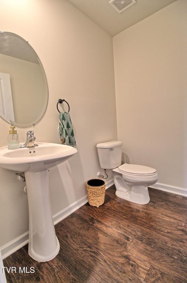 bathroom with wood-type flooring and toilet