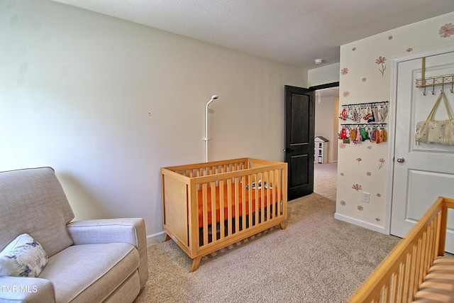 carpeted bedroom featuring a crib and a textured ceiling